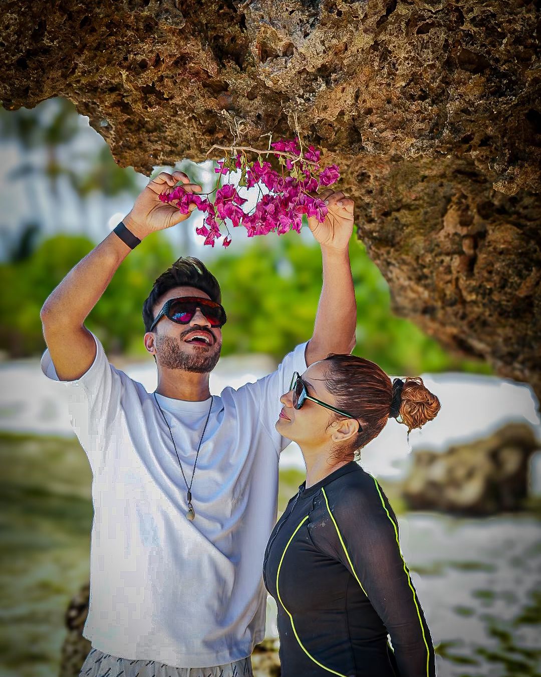 The setting of their photos is a beautiful island beach with mountains in the background, adding a dreamy vibe.